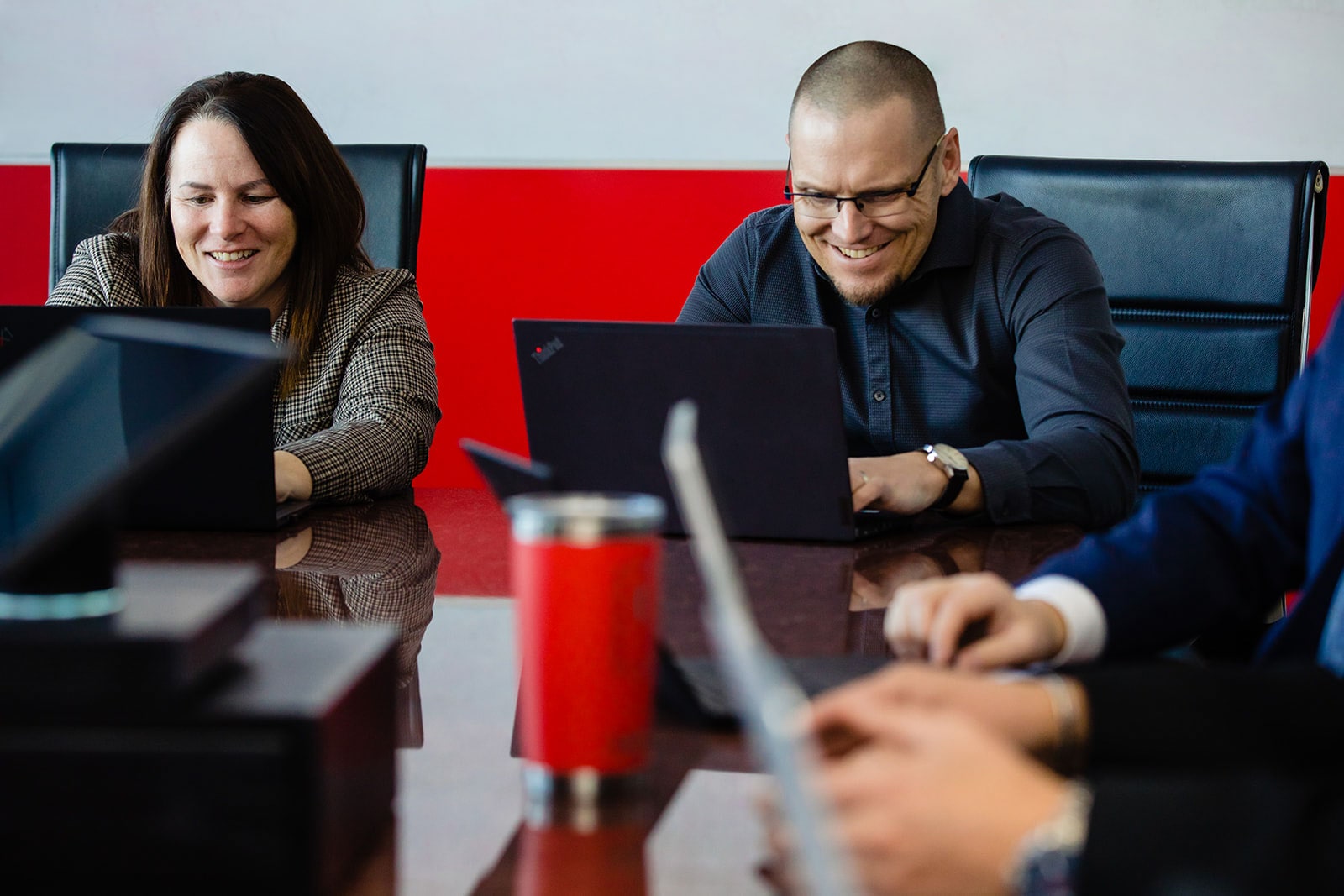 The Horizon Computer Solutions leadership team work together on laptops.