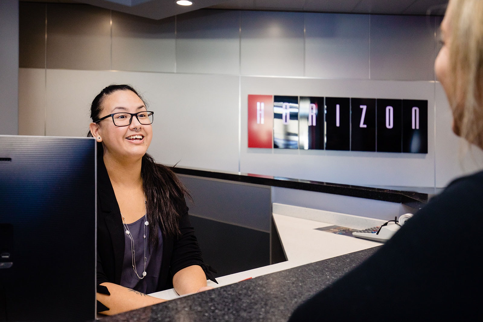 A woman greets a visitor to the Horizon office.