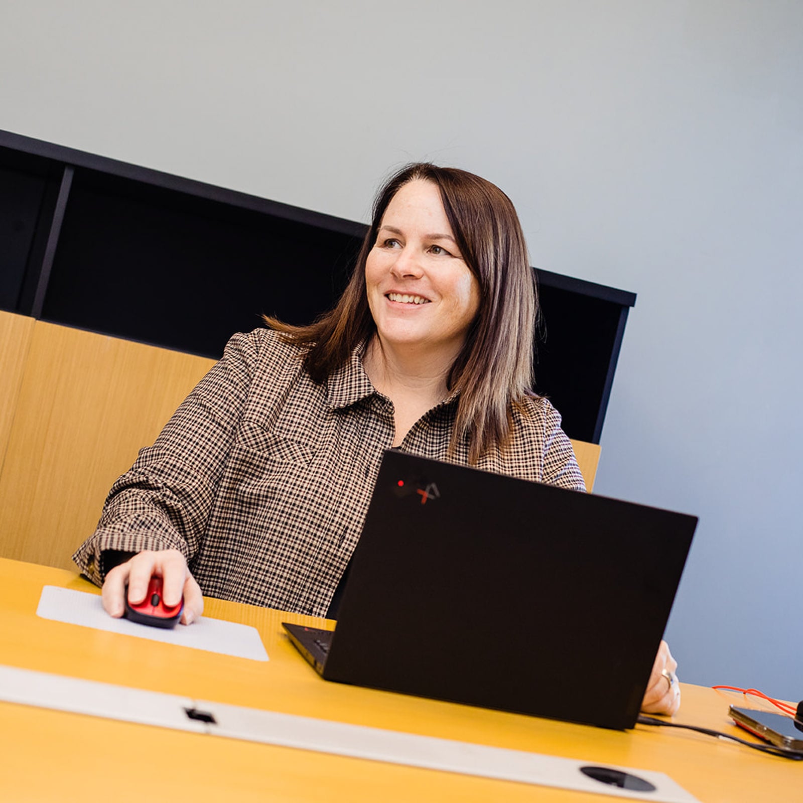 A Horizon Computer Solutions employee works at her desk on a laptop.